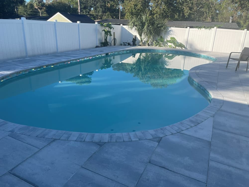Freeform gunite pool, Pebble finish, travertine deck