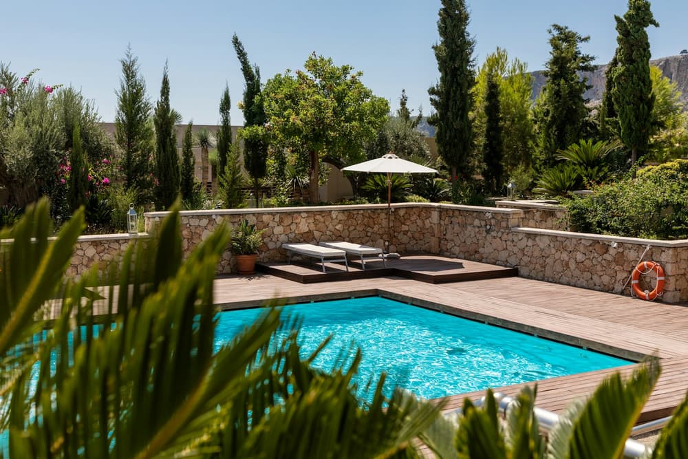 Courtyard pool with stone wall, Wood deck, desert-friendly planting